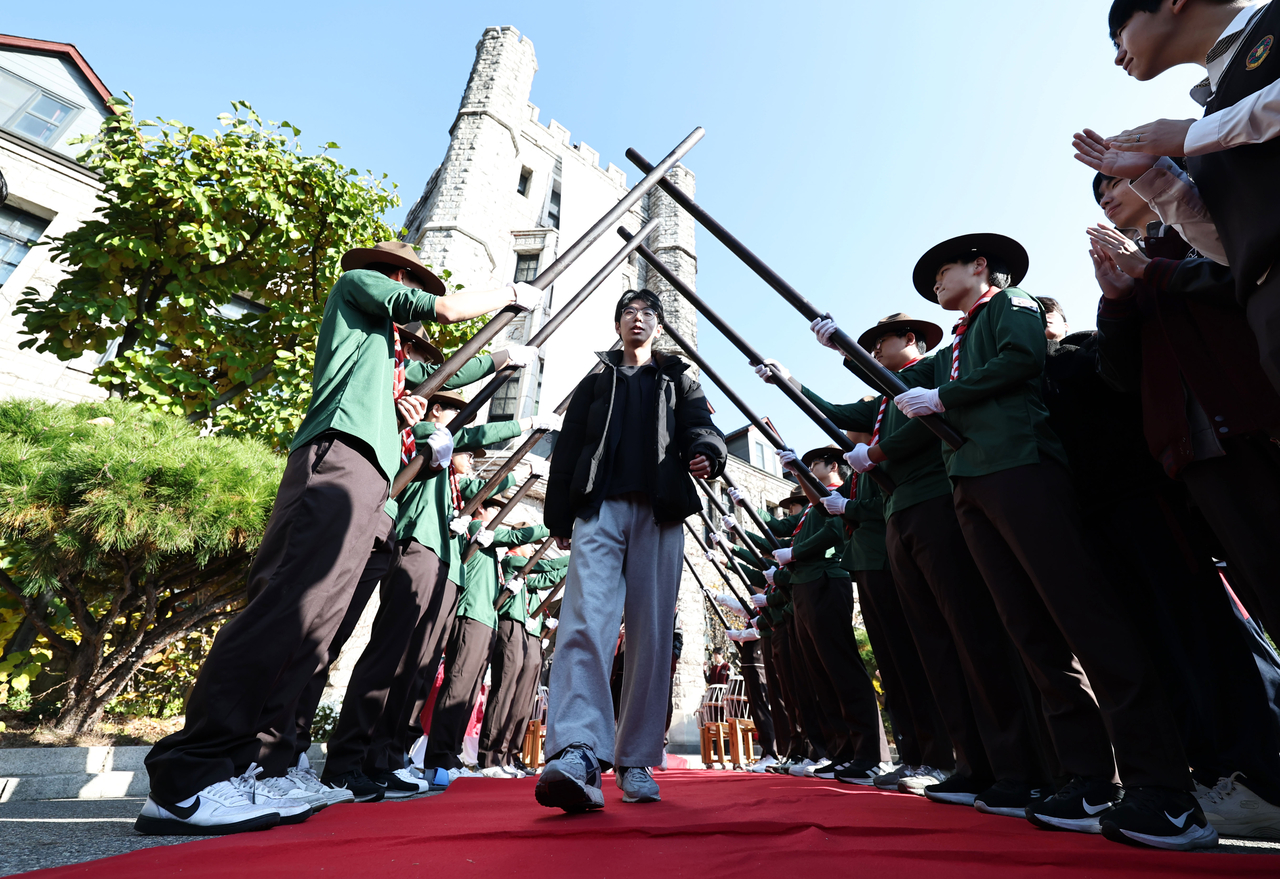 Choongang High School's seniors were escorted through a saber arch as they left the school grounds after picking up their test identification slip. (Yonhap)