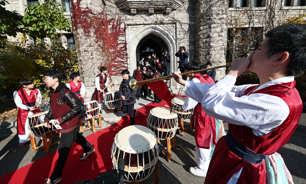 At Choongang High School, juniors fully decked out in traditional wear and playing traditional instruments. Test-takers were cheered on by juniors and teachers. (Yonhap)