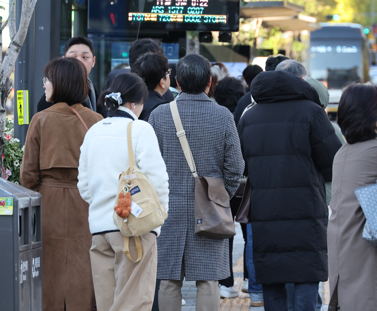 Commuters are seen waiting for the bus in winter jackets and coats in Seoul on Nov. 3. (Yonhap)