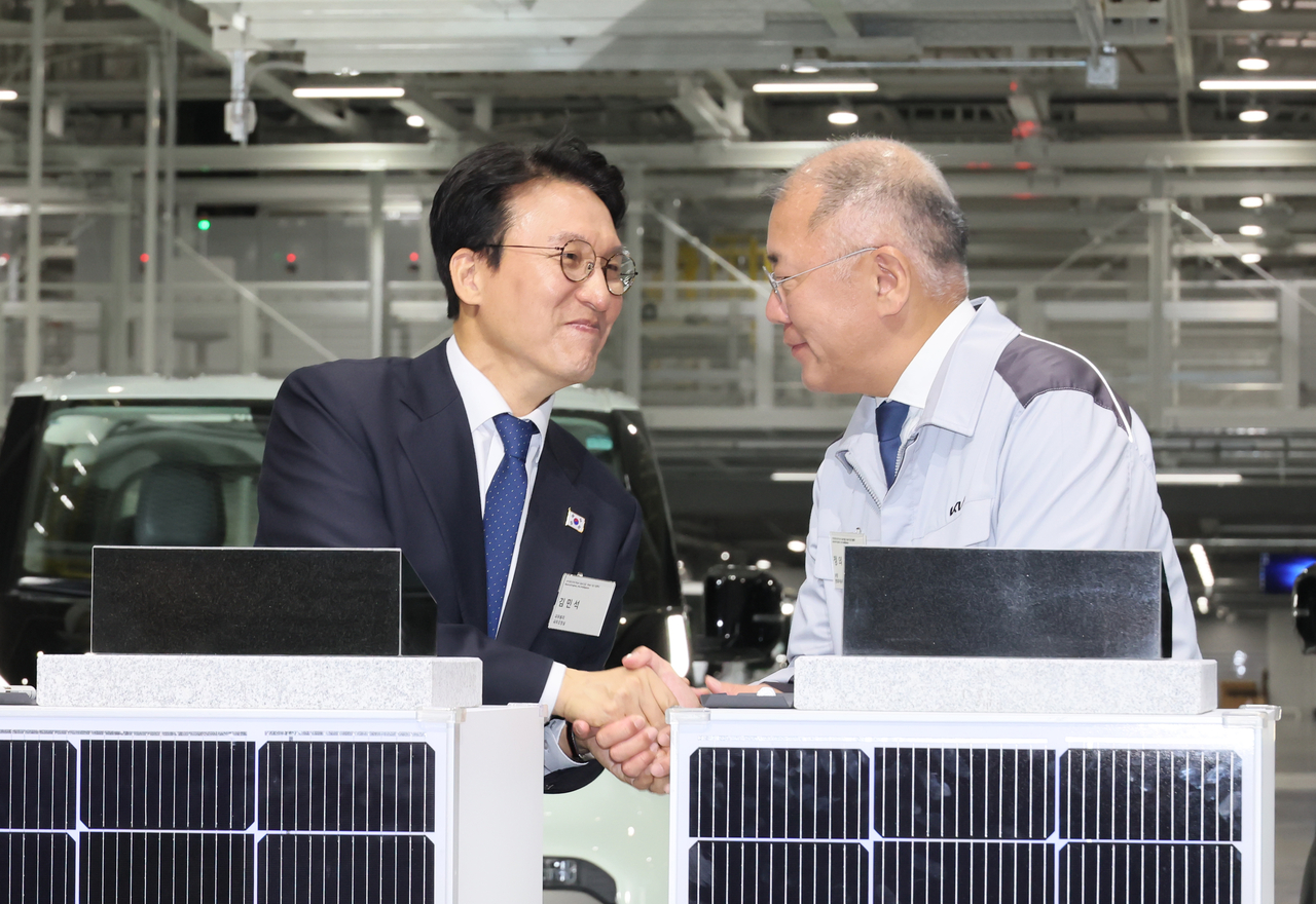 Hyundai Motor Group Executive Chair Chung Euisun (right) shakes hands with Prime Minister Kim Min-seok during the completion and groundbreaking ceremony of the Kia Hwaseong EVO Plant East and West in Gyeonggi Province on Friday. (Yonhap)