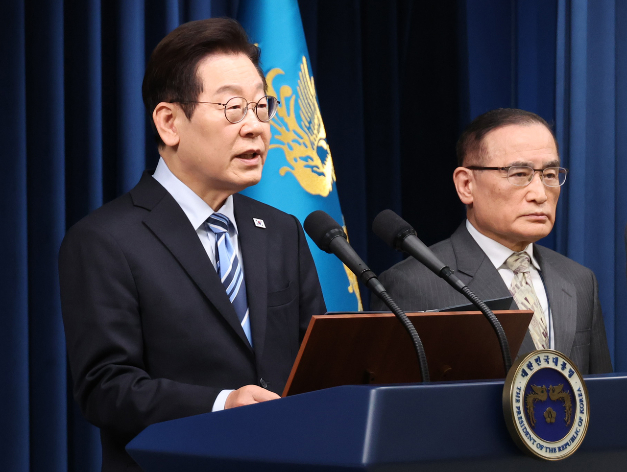 President Lee Jae Myung (left) speaks during a briefing at the presidential office in Yongsan-gu, central Seoul, on Friday, alongside National Security Adviser Wi Sung-lac. (Yonhap)