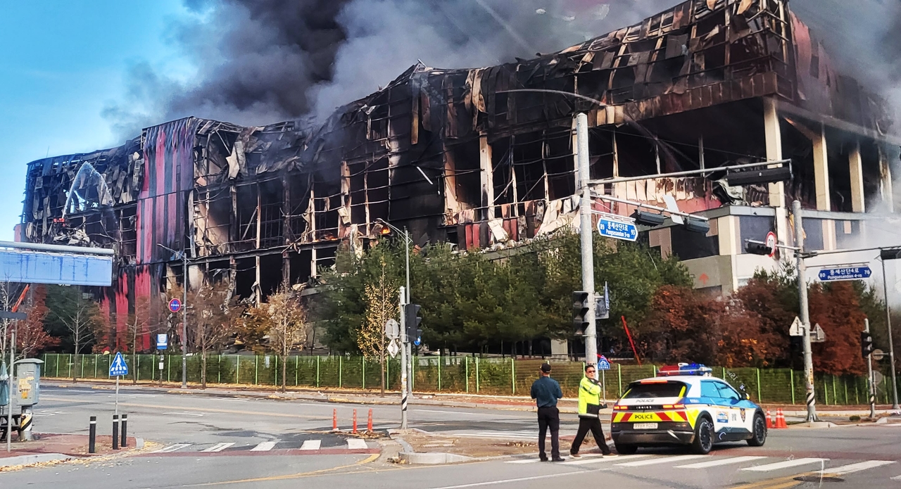The charred skeleton of the E-Land logistics hub is seen Saturday evening after firefighters brought the blaze under control, revealing the full scale of the destruction. (Yonhap)