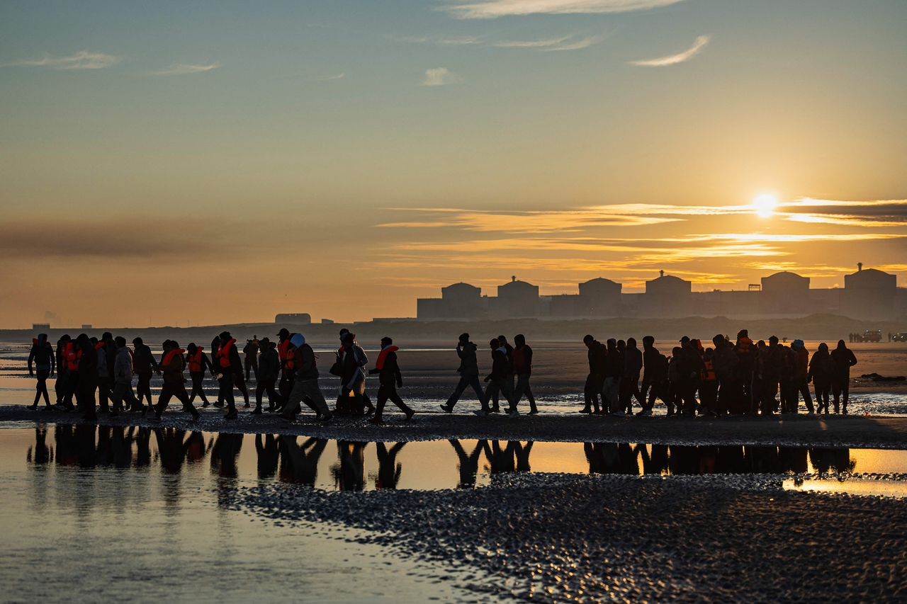 Migrants wade into the sea to try to board smugglers' boats in an attempt to cross the English Channel off the beach of Gravelines, northern France, Sept. 27. (AFP-Yonhap)
