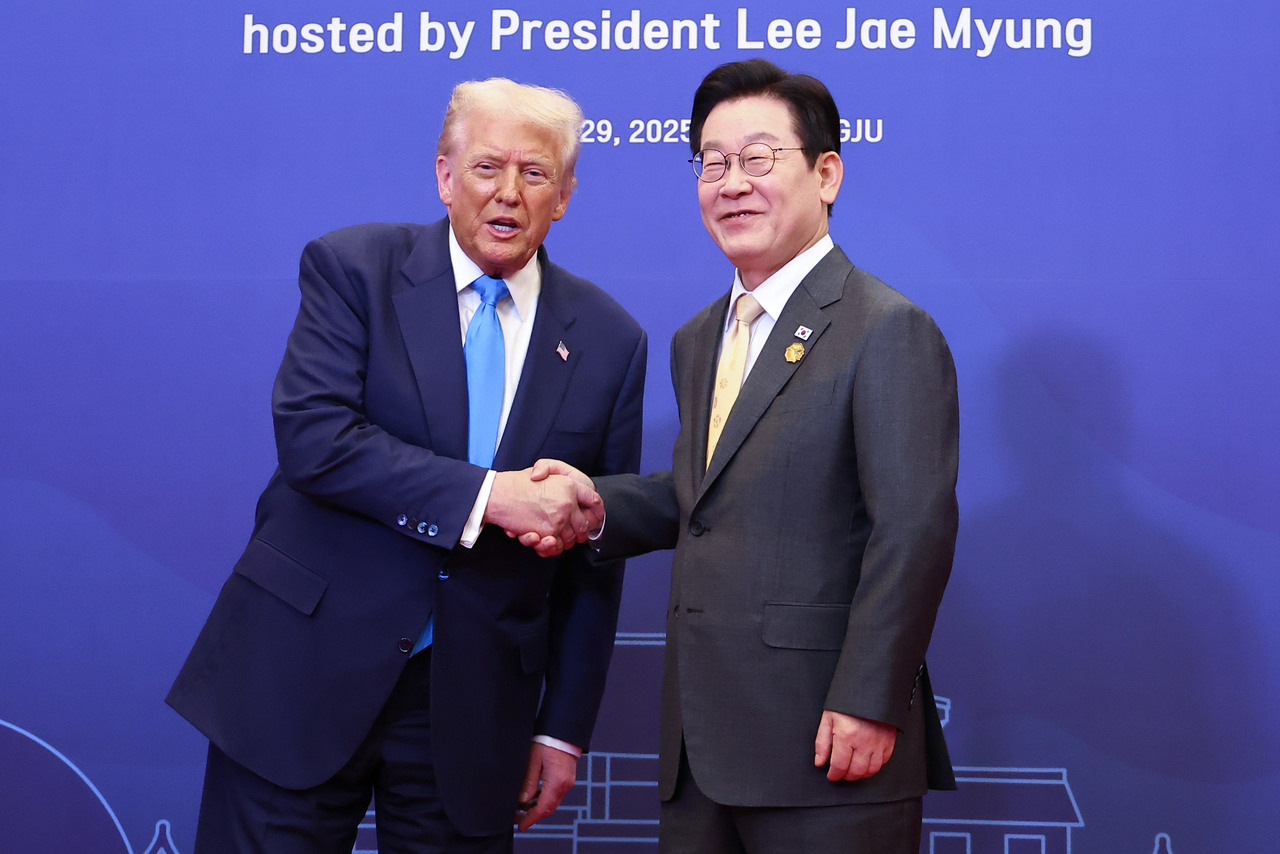 President Lee Jae Myung (R) shakes hands with US President Donald Trump in Gyeongju, southeastern South Korea, ahead of their special banquet, in this file photo taken Oct. 29. (Yonhap)