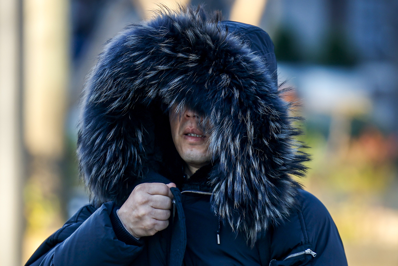 A commuter in heavy winter attire is pictured at Gwanghwamun Square on Tuesday morning, as temperatures fell below freezing across the country. (Newsis)