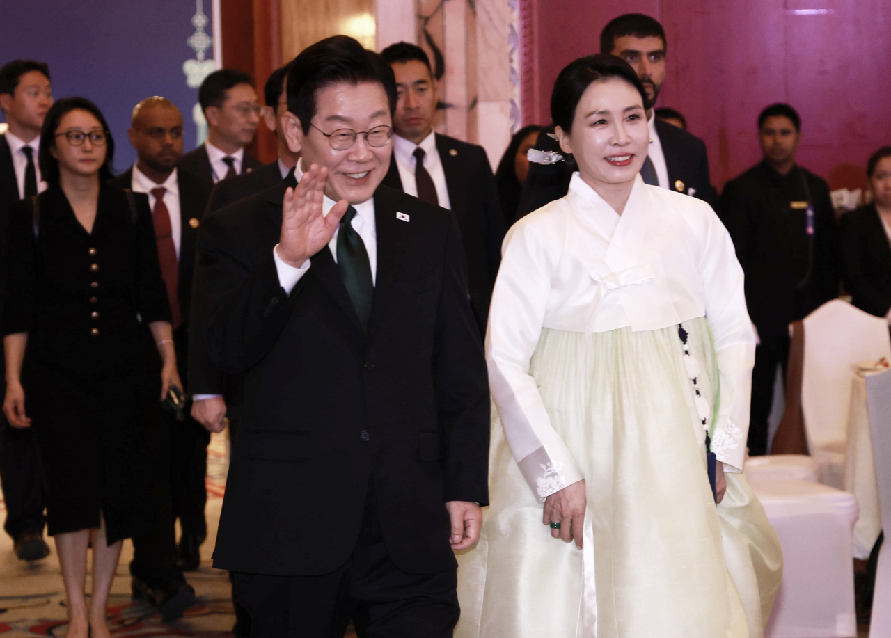 President Lee Jae Myung (L) and first lady Kim Hea Kyung greet Korean residents in the United Arab Emirates held at a hotel in Abu Dhabi on Monday. (Yonhap)