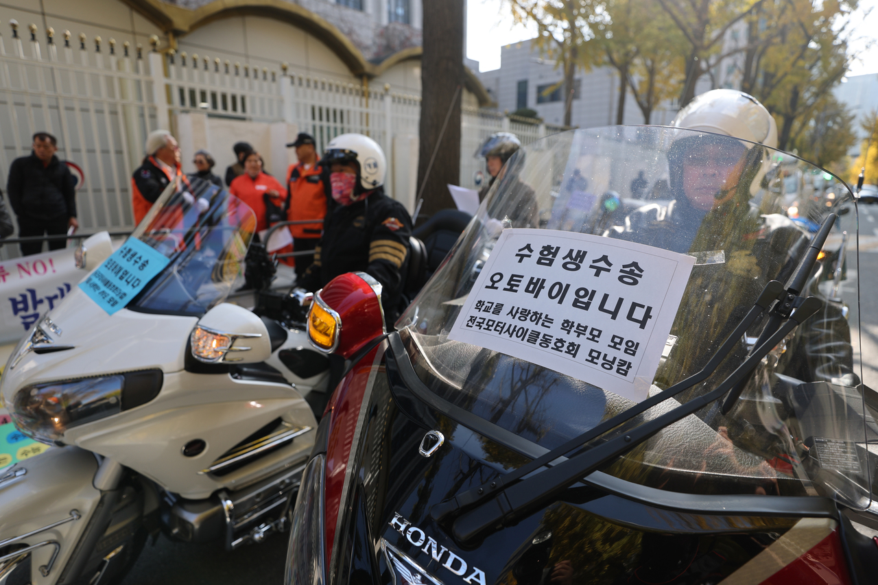 Volunteer riders wait for Suneung takers in front of test sites in Seoul. (Yonhap)