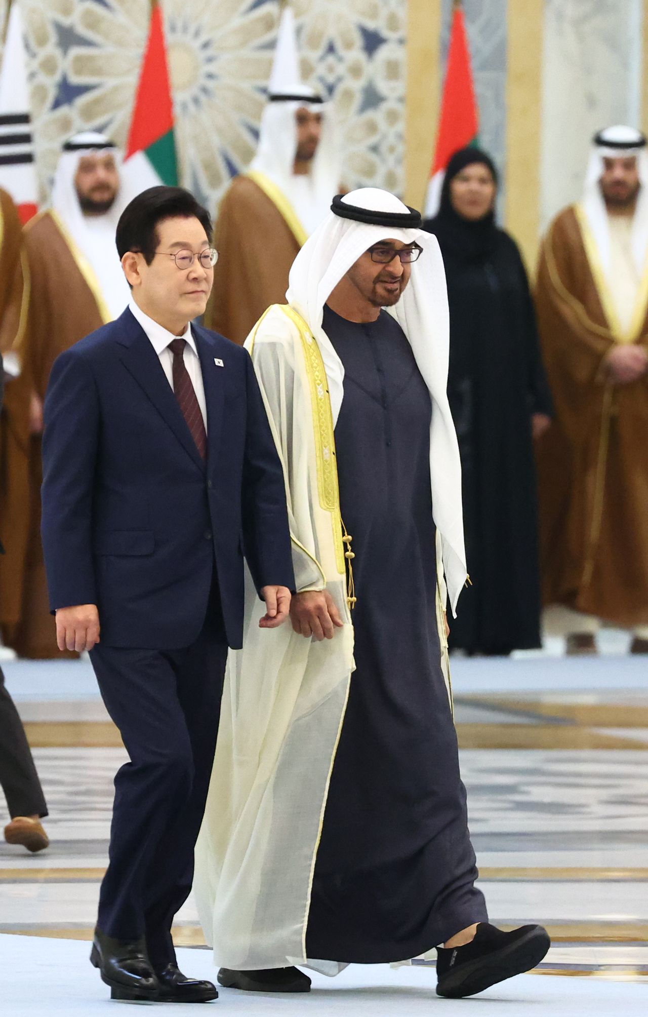 President Lee Jae Myung (left) and UAE President Mohamed bin Zayed Al Nahyan walk side by side at the Qasr Al Watan presidential palace in Abu Dhabi in the UAE on Tuesday. (Yonhap)