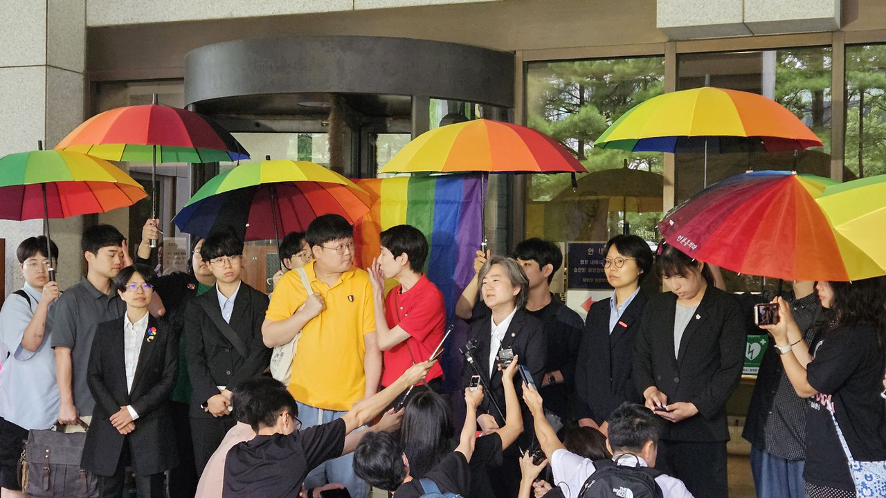 In July 2024, same-sex couple So Sung-wook (in yellow) and Kim Yong-min (in red) hold a press briefing after the Supreme Court upheld their right to register as health insurance dependents. The ruling marked South Korea’s first legal recognition of certain rights for same-sex partnerships. (Amnesty International Korea)