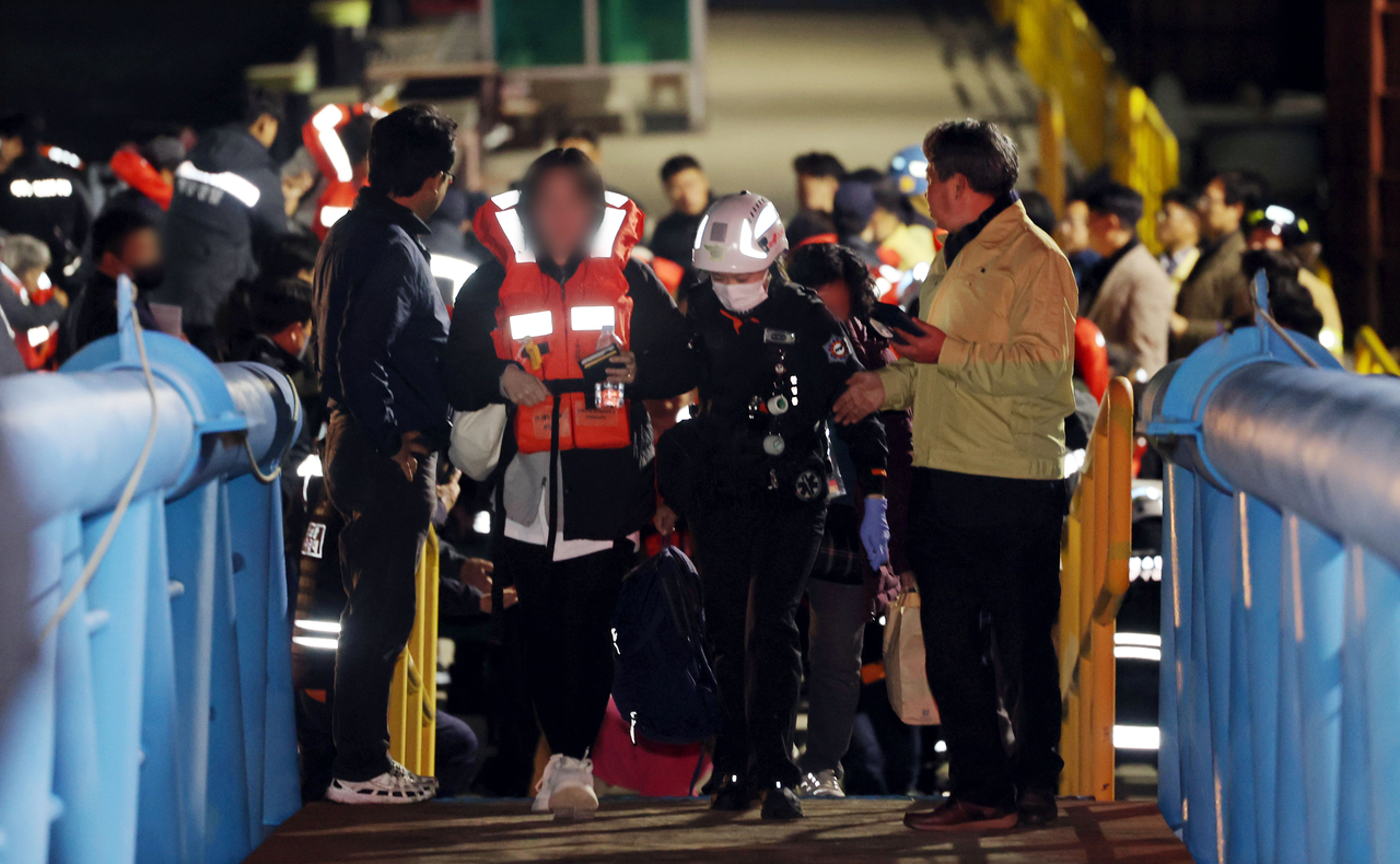 Passengers aboard the Queen Jenuvia 2, which ran aground near Sinan County, South Jeolla Province are seen being rescued by authorities late Wednesday. (Yonhap)