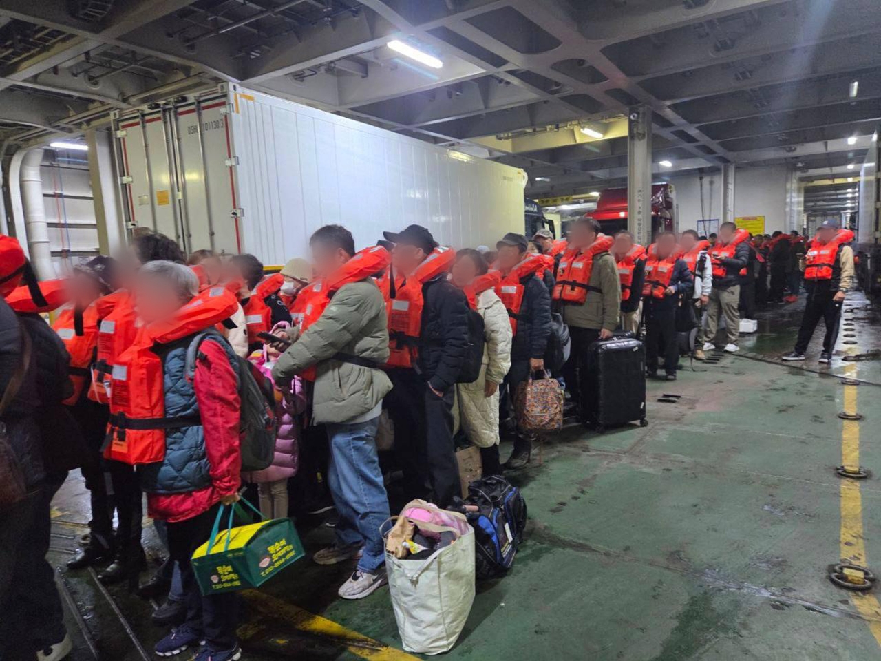 Passengers wait on deck with life jackets as rescue crews arrive. (Yonhap)