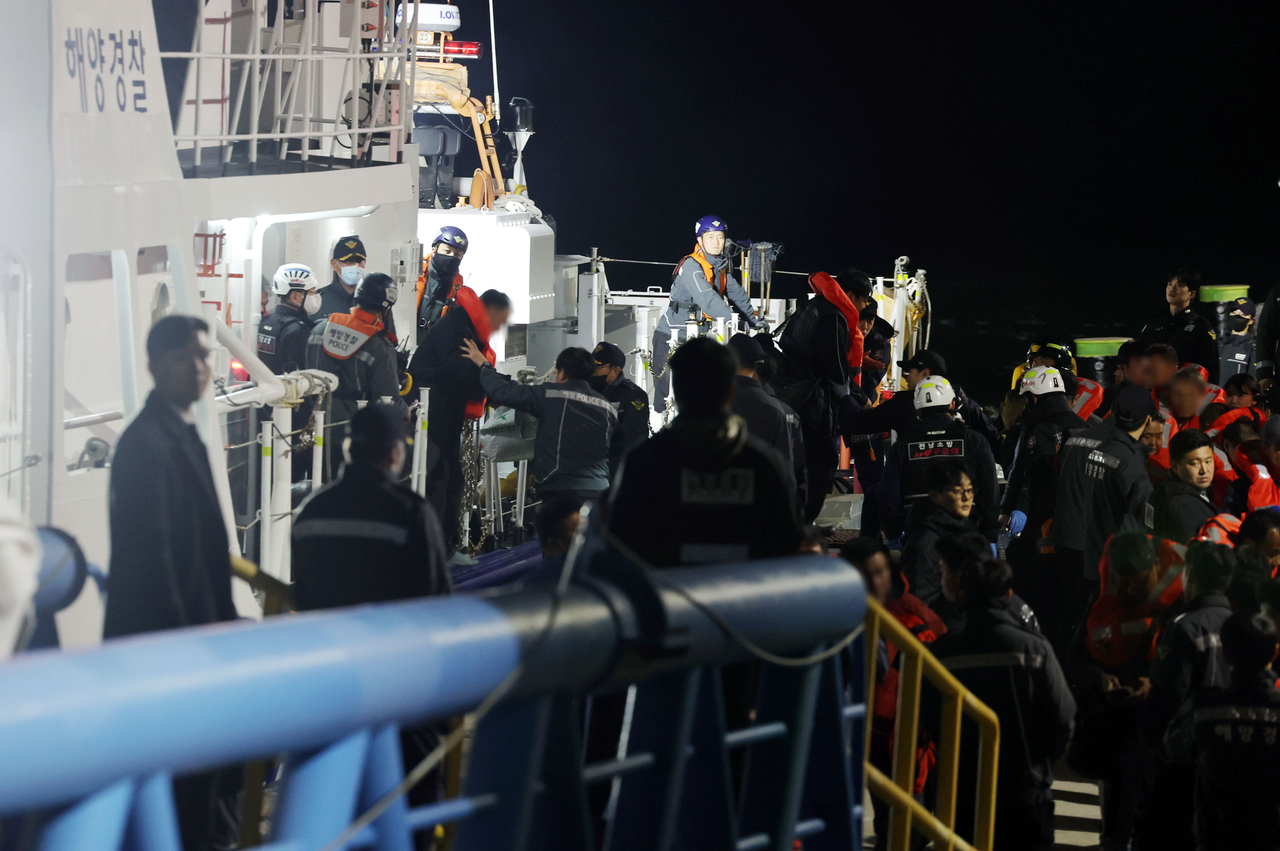 Passengers from the Queen Jenuvia II are brought to the Mokpo Coast Guard pier early Thursday after the ferry ran aground near Jokdo, south of Jangsan Island in Sinan County, late Wednesday.  (Yonhap)
