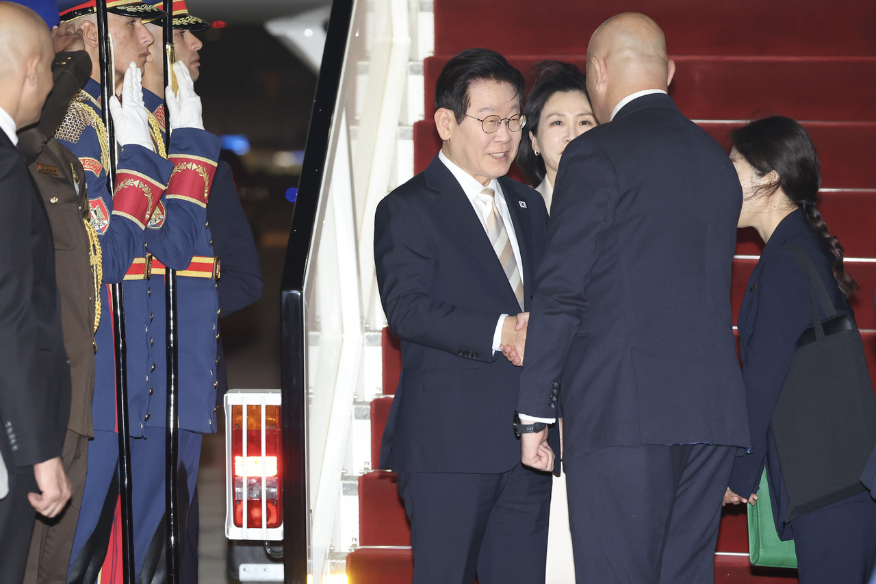 President Lee Jae Myung (L) arrives at Cairo International Airport in Cairo, Egypt, on Wednesday. (Yonhap)
