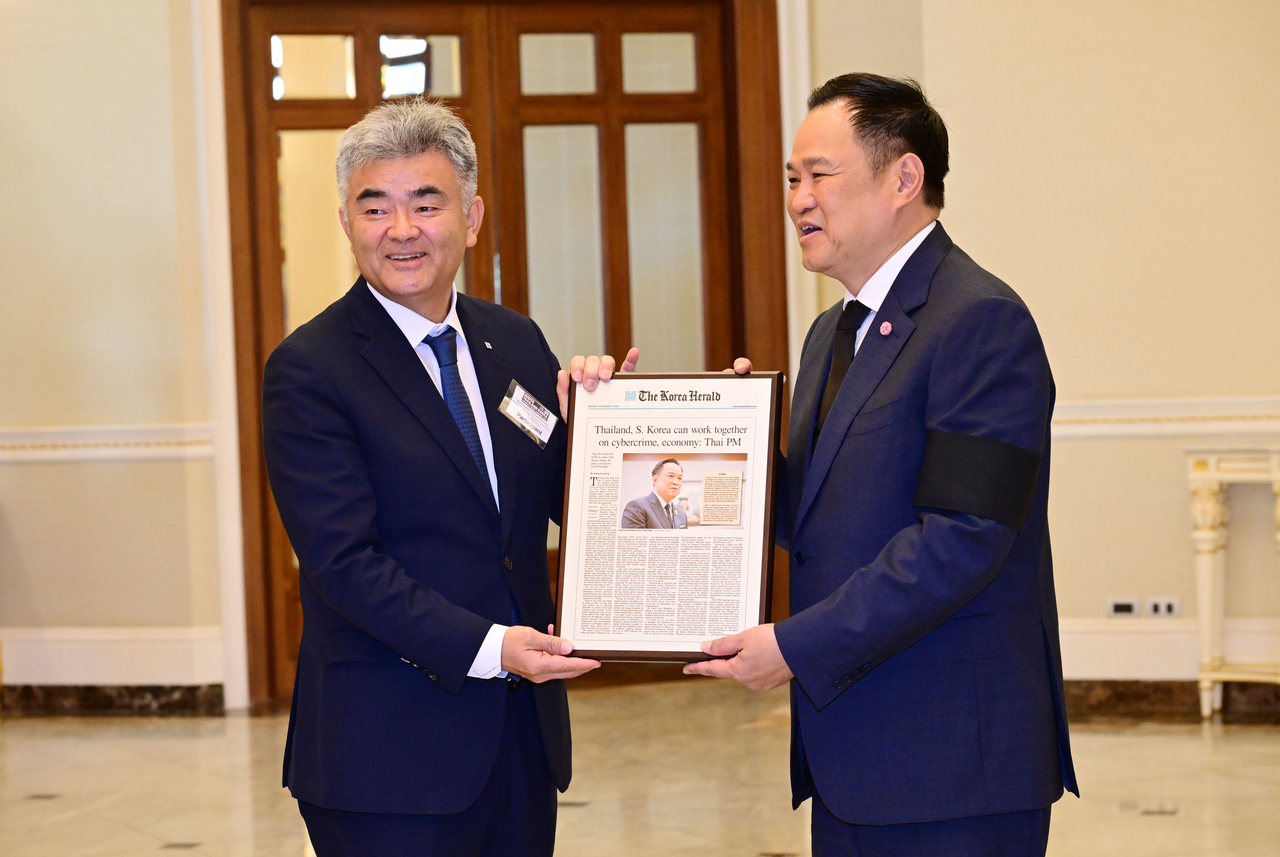 Jung Won-ju (left), chairman of Daewoo E&C and Herald Media Group, and Thai Prime Minister Anutin Charnvirakul hold a bronze plaque featuring his interview with The Korea Herald for a photo at the Government House of Thailand in Bangkok on Tuesday. (Park Hae-mook/The Korea Herald)