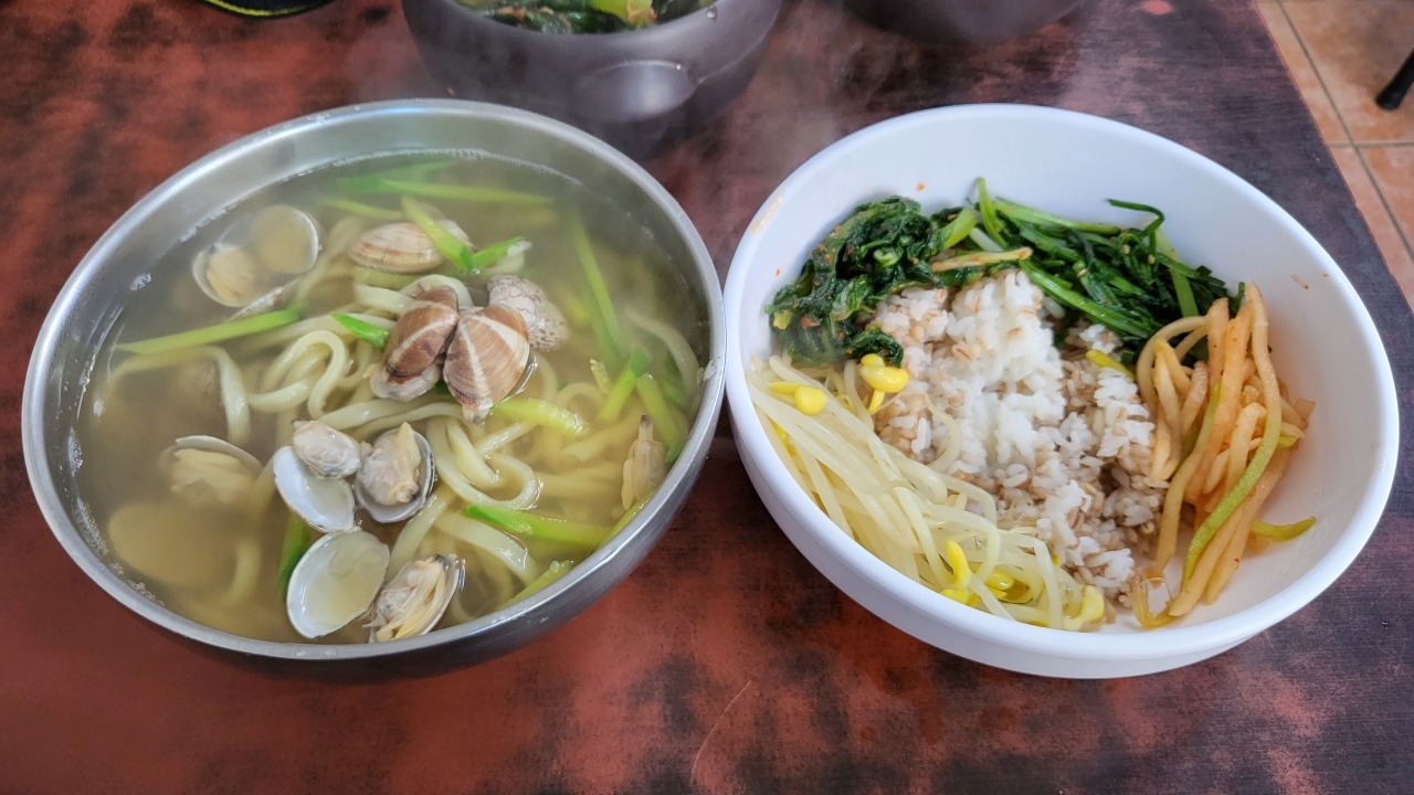 A bowl of kalguksu (left) alongside rice and vegetables (Herald DB)