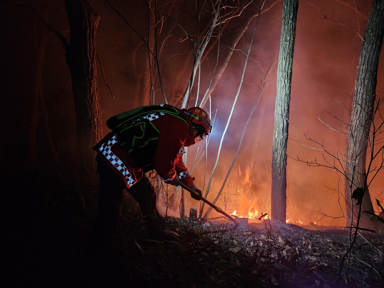A firefighter puts out a wildfire in the mountains of Yangyang, about 155 kilometers northeast of Seoul, on Sunday, in this photo provided by the Korea Forest Service. (Yonhap)
