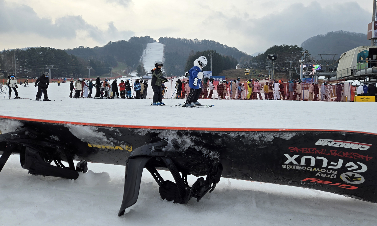 A snowboard lies on the ground at Yongpyong Ski Resort in Pyeongchang, Gangwon Province, on Sunday. (Yonhap)