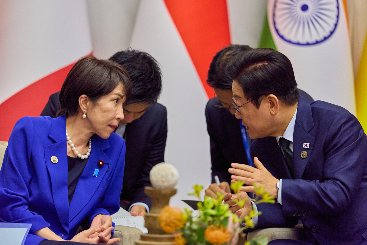 President Lee Jae Myung (right) and Japanese Prime Minister Sanae Takaichi hold talks in Johannesburg, Sunday. (Pool photo via Yonhap)