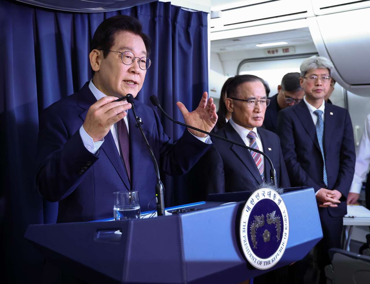 President Lee Jae Myung (left) speaks in a press conference while aboard Air Force One bound for Ankara, Turkey, before arriving in the country for a state visit there on Monday. (Yonhap)
