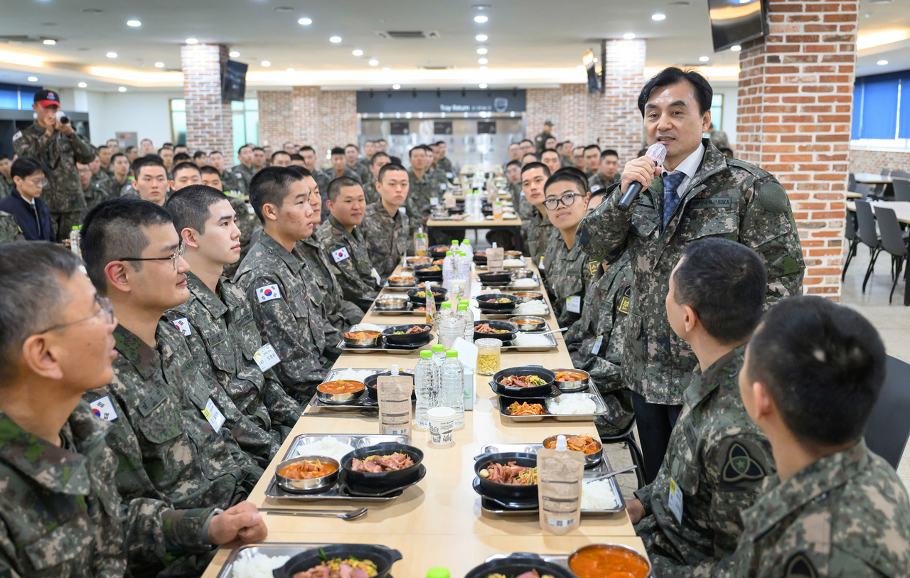 Defense Minister Ahn Gyu-back (standing) speaks with soldiers during a visit to the Army’s 35th Recruit Training Battalion on Thursday. (Newsis)