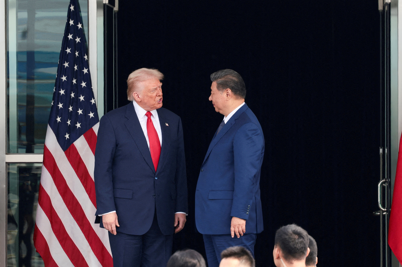 US President Donald Trump (left) and Chinese President Xi Jinping talk as they leave after a bilateral meeting at Gimhae International Airport in Busan on Oct. 30.   Reuters-Yonhap