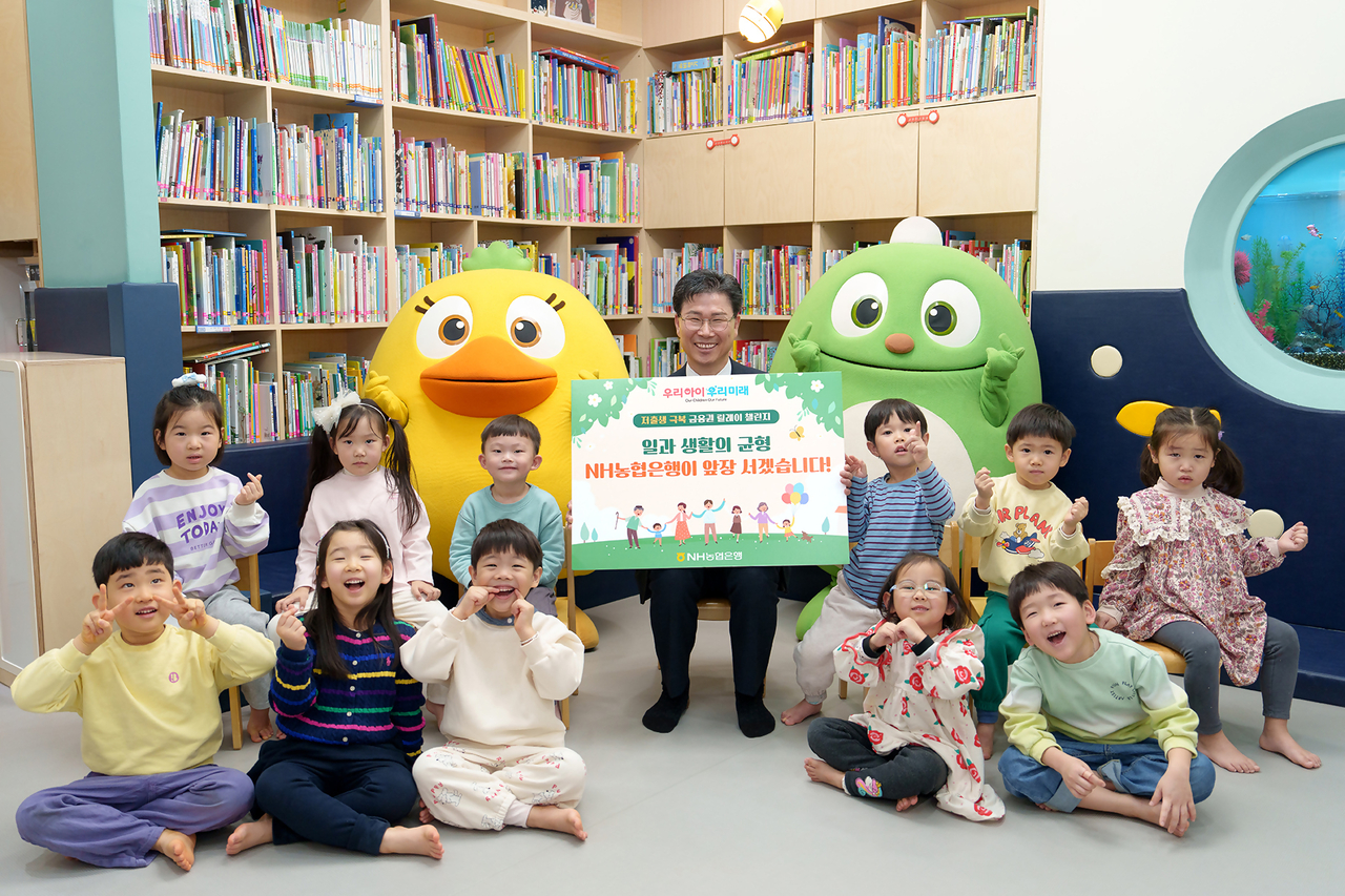 NH Nonghyup Bank CEO Kang Tae-young poses for a photo with children at the bank's in-house day care center in Seoul on Feb. 19. (NH Nonghyup Bank)