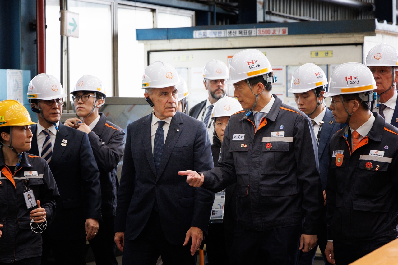 Hanwha Group Vice Chairman Kim Dong-kwan (second from right) guides Canadian Prime Minister Mark Carney at Hanwha Ocean's Geoji Shipyard in South Gyeongsang Province on Oct. 30. (Hanwha Group)
