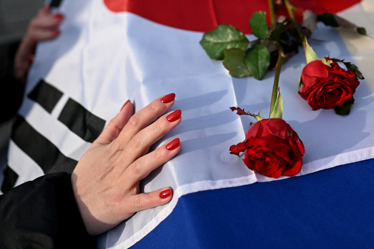 A woman pays tribute next to the coffin of a slain South Korean volunteer soldier of the 2nd International Legion during a farewell ceremony on Independence Square in Kyiv on November 25, 2025, amid the Russian invasion of Ukraine. (Yonhap-AFP)
