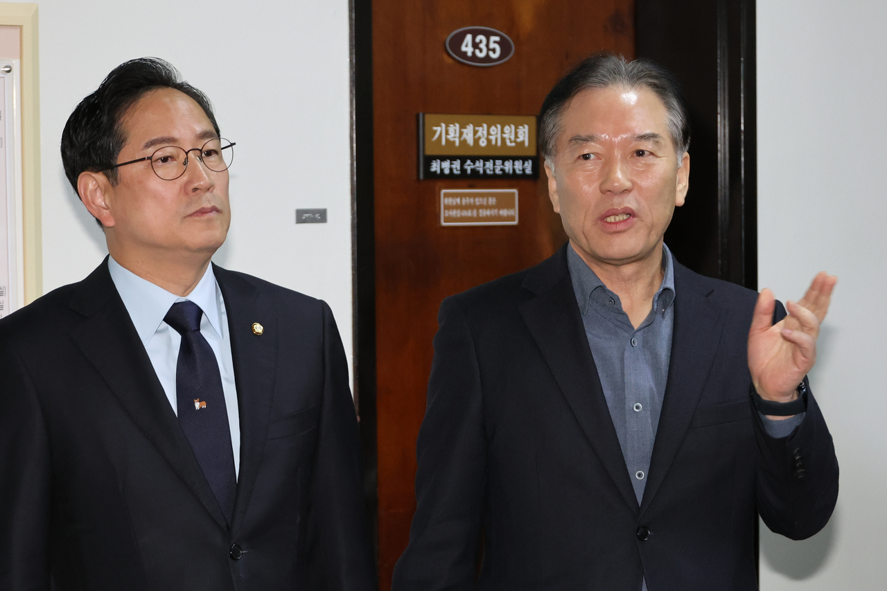 Reps. Jung Tae-ho (left) of the Democratic Party and Park Soo-young of the People Power Party speak to reporters on Friday at the National Assembly’s Strategy and Finance Committee about the progress of their closed-door negotiations, including an agreement on separate taxation for dividend income. (Yonhap)