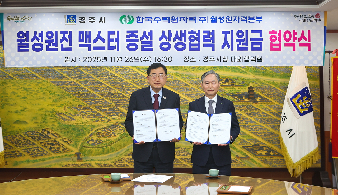 주낙영 경주시장(왼쪽)과 권원택 한국수력원자력 월성원자력본부장이 26일 경주시청 대외협력실에서 월성원전 맥스터 증설 상생협력 지원금 협약을 체결한 뒤 협약서를 들어 보이고 있다.[경주시 제공]