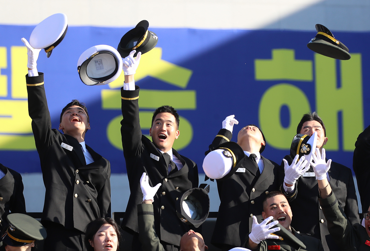 Lee Ji-ho (second from left), son of Samsung Electronics Chair Lee Jae-yong, is seen tossing his hat in celebration during a commissioning ceremony for the 139th class of officer candidates at the Republic of Korea Naval Academy in Changwon, South Gyeongsang Province, Friday. (Joint Press Corps)
