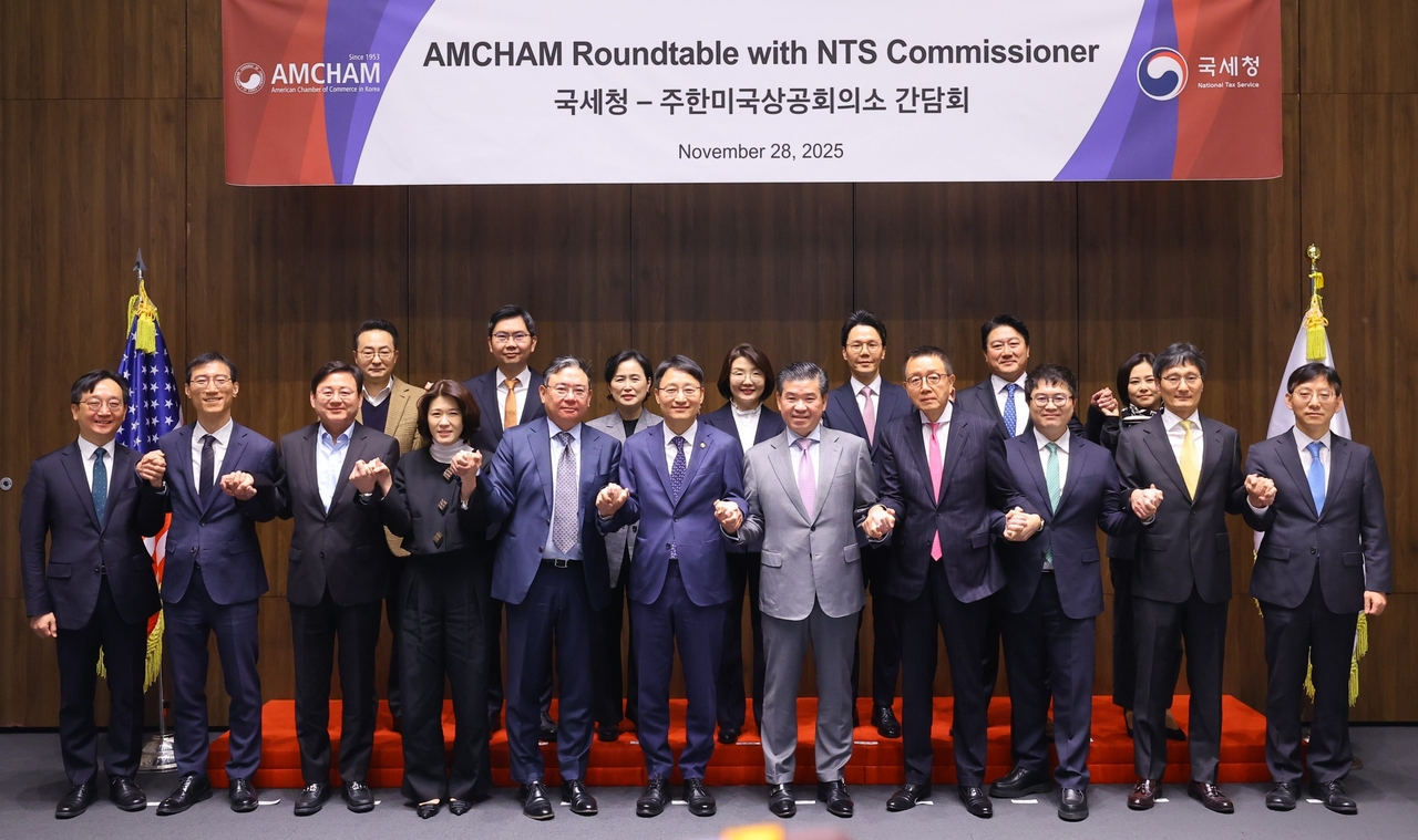 National Tax Service Commissioner Lim Kwang-hyun (front, sixth from left) and AmCham Chairman and CEO James Kim (front, seventh from left) pose for a group photo with participants during a roundtable meeting in Seoul on Friday. (AmCham)