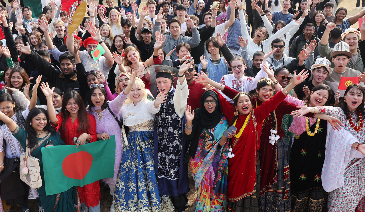Foreign students dressed in traditional attire pose for a photo and share a joyful moment during a festival held at Ajou University in Suwon, Gyeonggi Province, in November. (Yonhap)
