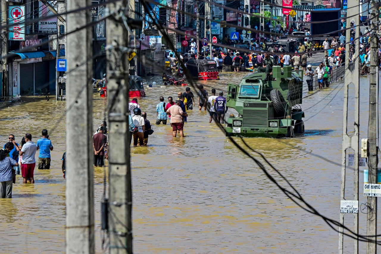Damaged wires dangle from electric poles as an army truck wades through a flooded street after heavy rainfall in Wellampitiya on the outskirts of Colombo on Sunday. (Yonhap-AFP)
