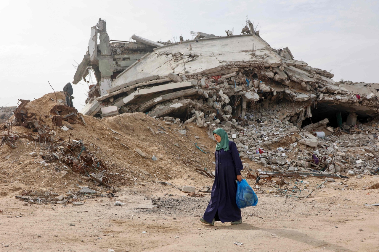 A displaced Palestinian woman walks past a destroyed building in Tel al-Hawa neighborhood, southern Gaza City, Saturday.    (AFP-Yonhap)