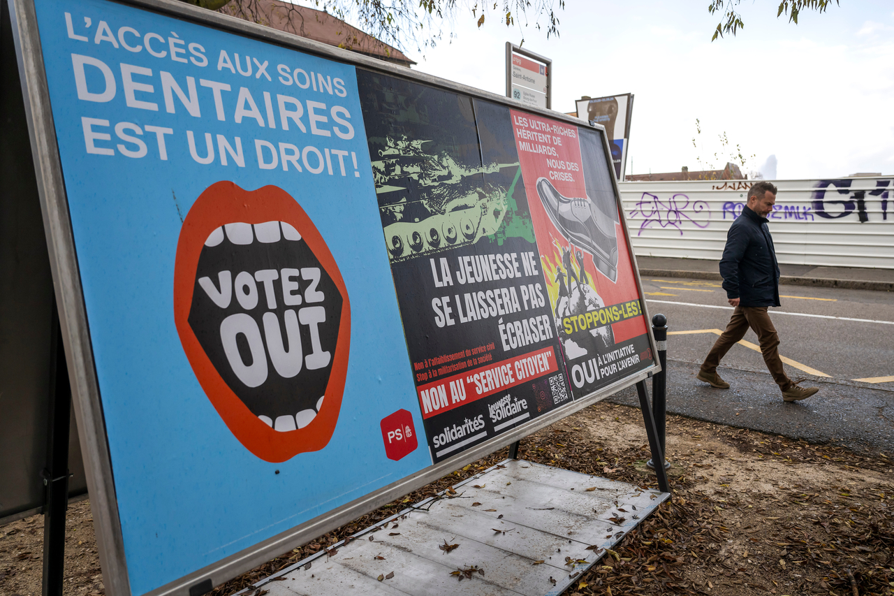 A person walks past referendum posters of political parties and associations in Geneva, Switzerland, on Wednesday.   AP-Yonhap