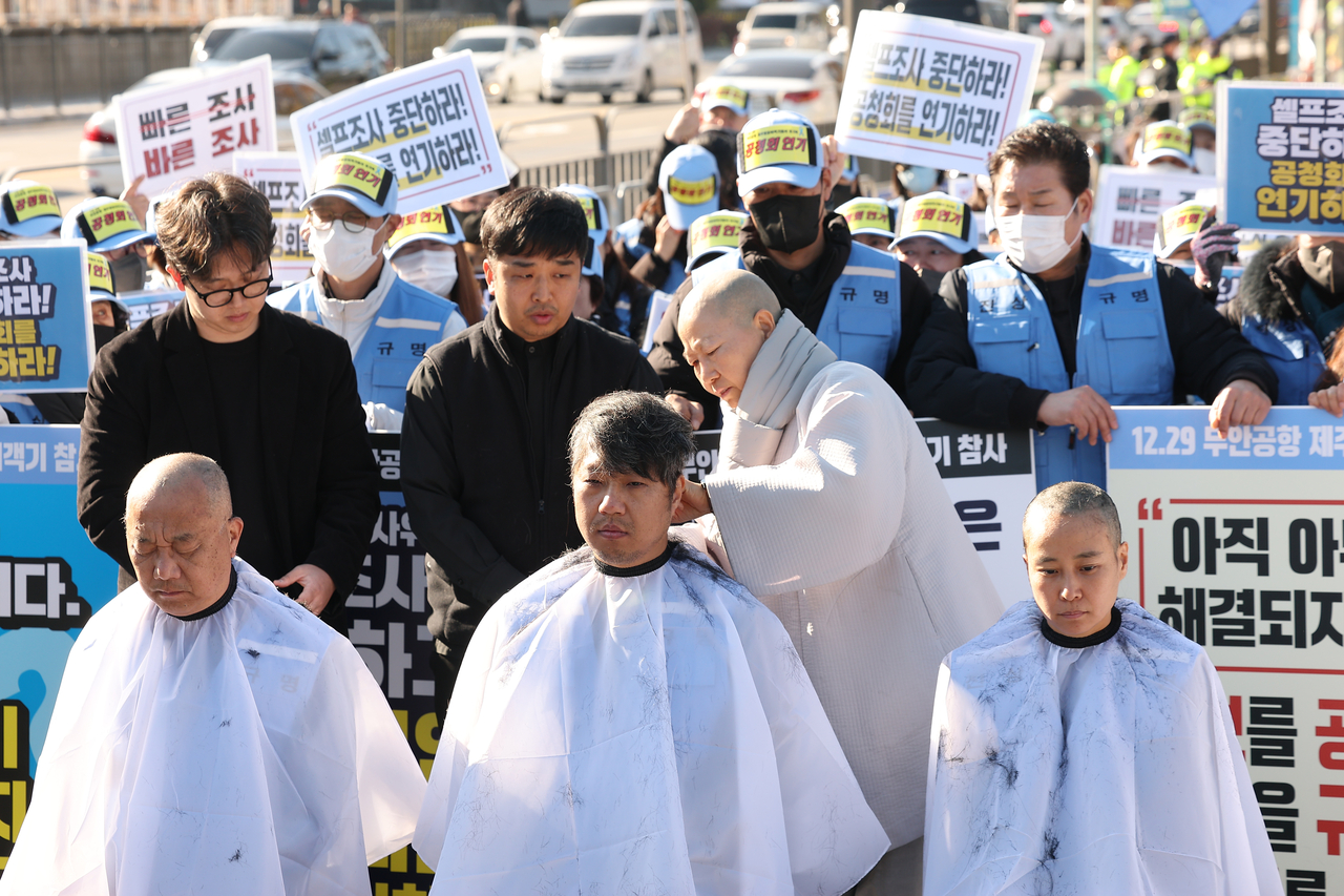 Relatives of the victims of the Jeju Air crash in December 2024 shave their heads as they begin an indefinite sit-in in front of the presidential office on Monday. (Yonhap)