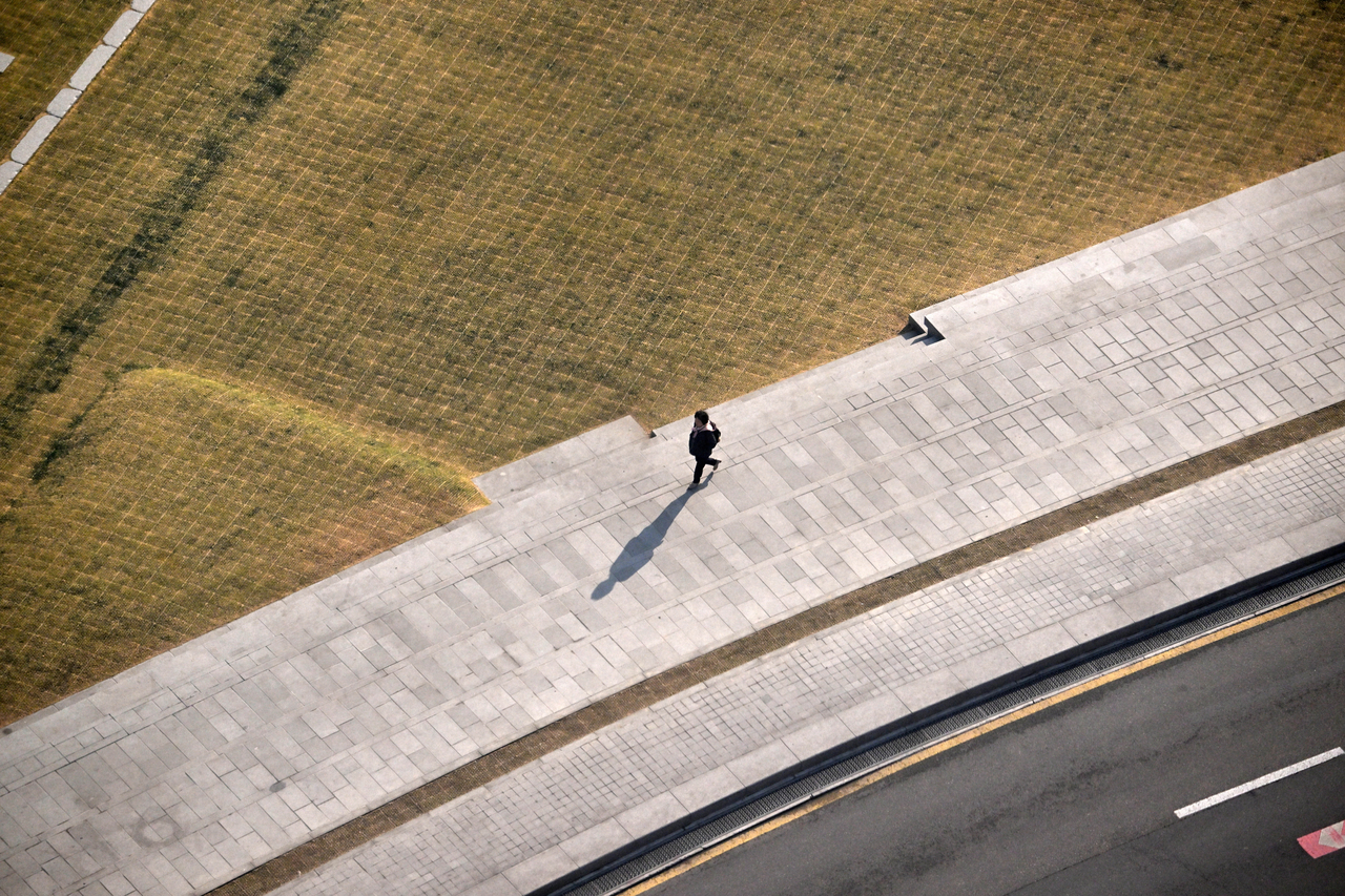 A passerby walks along the sidewalk near Gwanghwamun in Seoul on April 7, after scores of tents were taken down there following the Constitutional Court's ruling to uphold the impeachment of President Yoon Suk Yeol. Im Se-jun/The Korea Herald