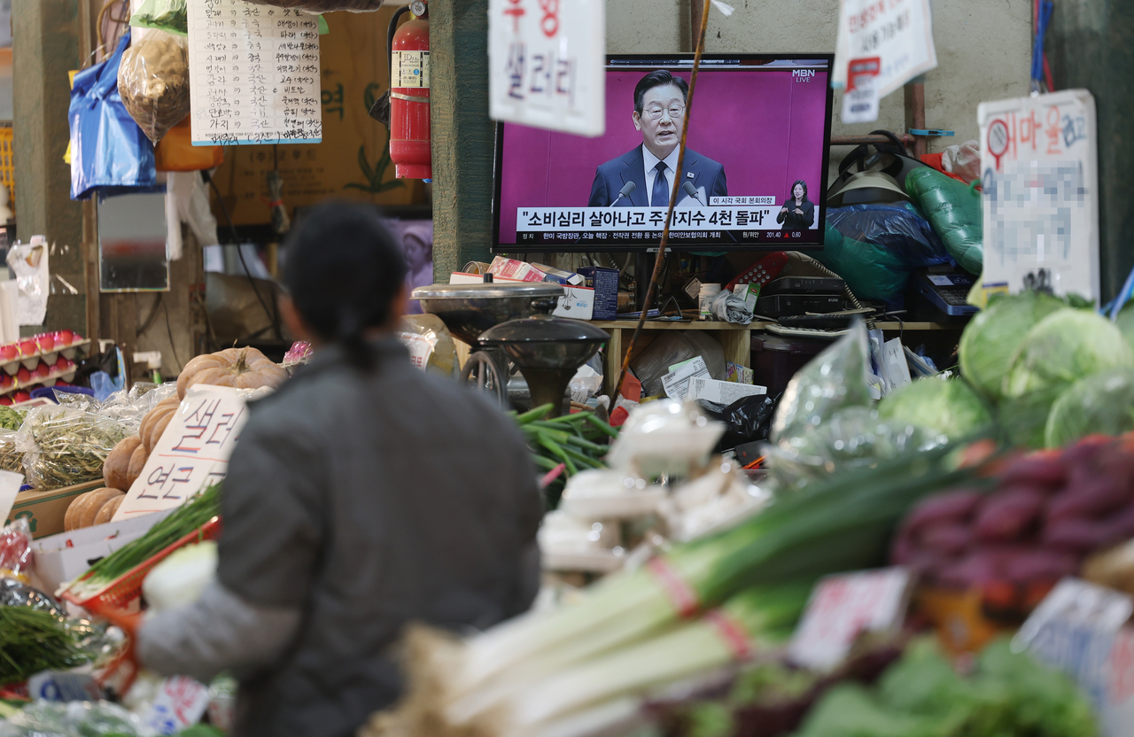 At a traditional market in Seodaemun-gu, Seoul, a merchant watches President Lee Jae Myung deliver his 2026 budget speech during a plenary session of the National Assembly on Nov. 4. (Yonhap)