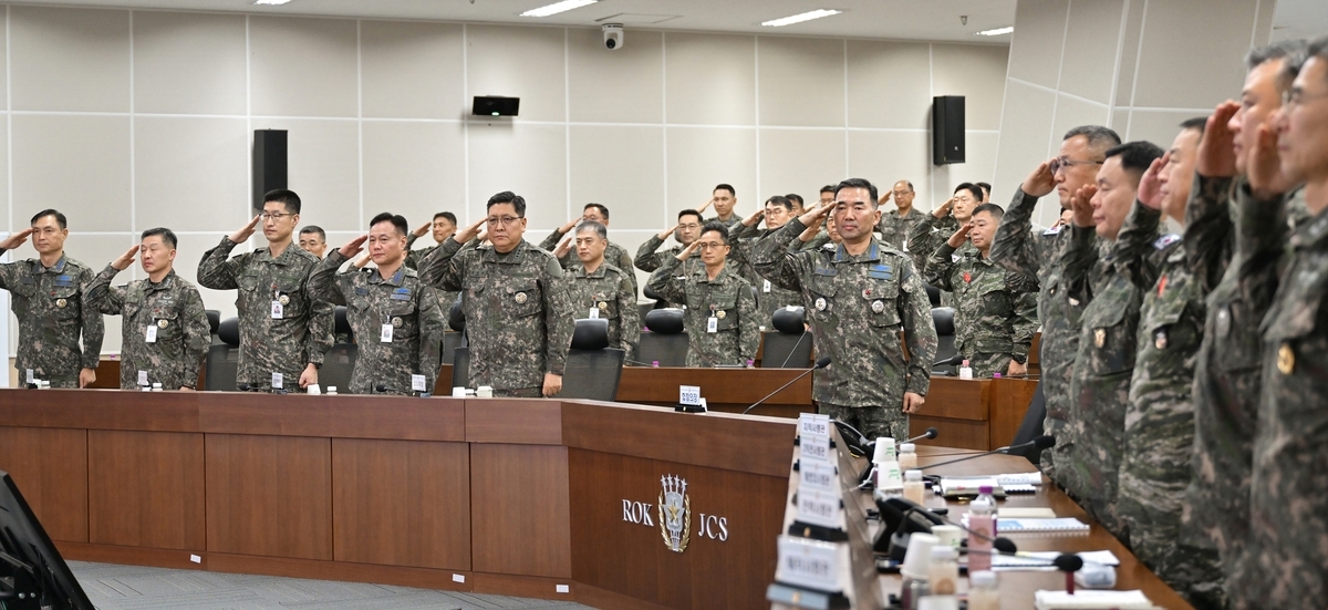 This photo, provided by the Joint Chiefs of Staff, shows JCS Chairman Gen. Jin Yong-sung (center) saluting the flag ahead of a meeting of key field commanders on Wednesday. (Joint Chiefs of Staff via Yonhap)