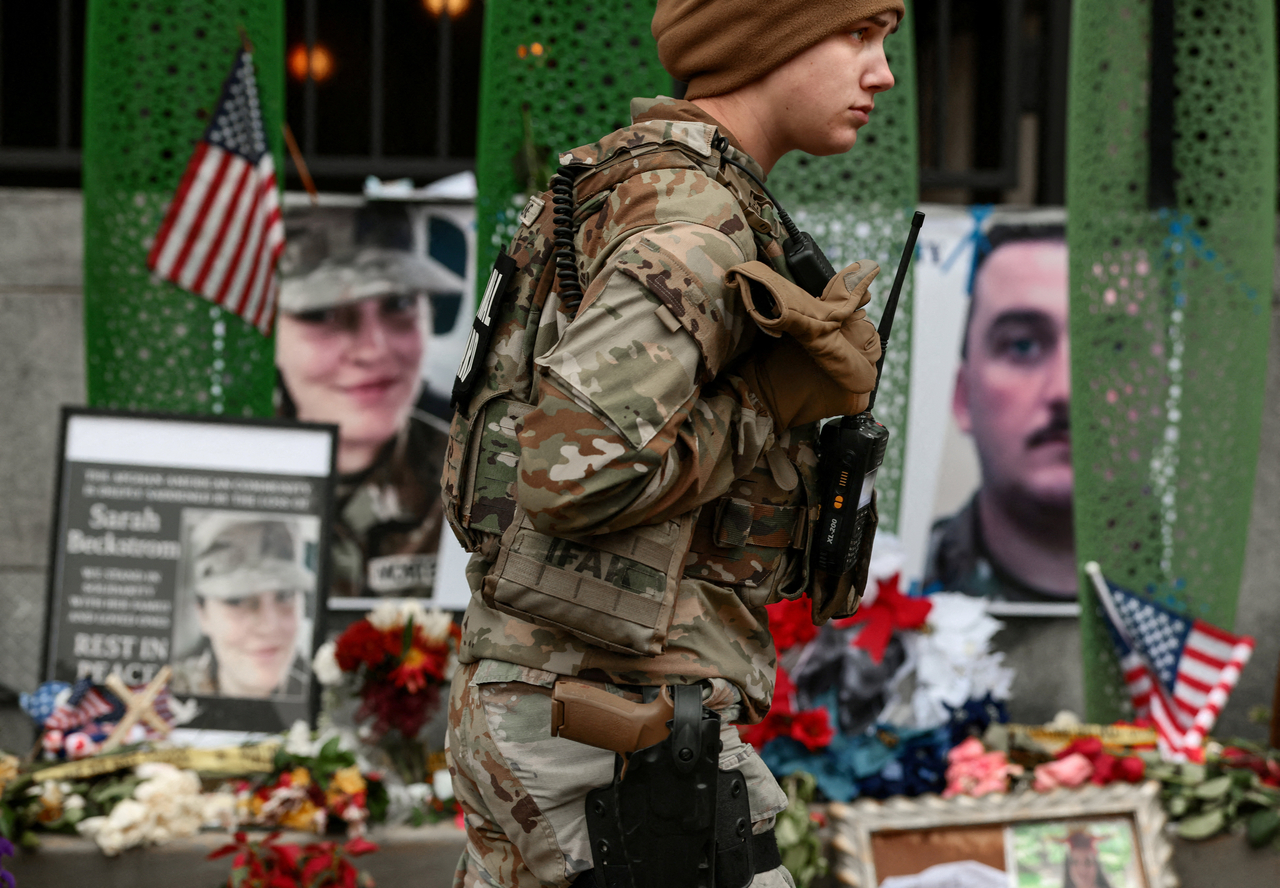 A US National Guard soldier from Alabama walks near a makeshift memorial in Washington, Tuesday. (Reuters-Yonhap)