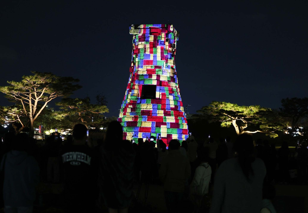 Visitors watch a special media art projection show at Cheomseongdae, a Silla-era astronomical observatory, during a cultural event in Gyeongju, North Gyeongsang Province, on Monday. (Yonhap)