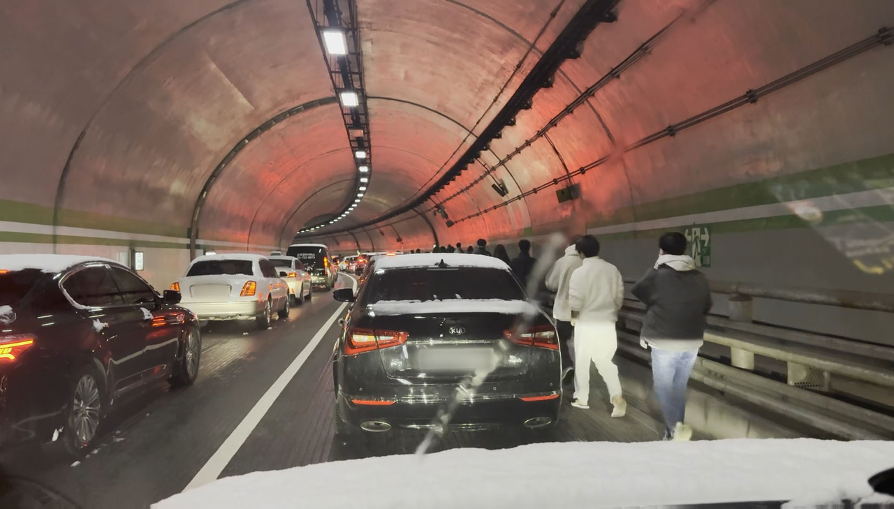 Commuters are seen walking after getting off a bus inside Jahamun Tunnel in Jongno-gu, Seoul, on Thursday. (Yonhap)