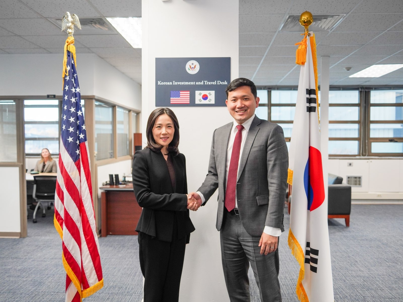 South Korean Second Vice Foreign Minister Kim Jina (left) and Kevin Kim, chargé d’affaires ad interim at the US Embassy in Seoul, shake hands during the inauguration ceremony for the Korean Investment and Travel Desk at the embassy on Friday. (Republic of Korea Ministry of Foreign Affairs)