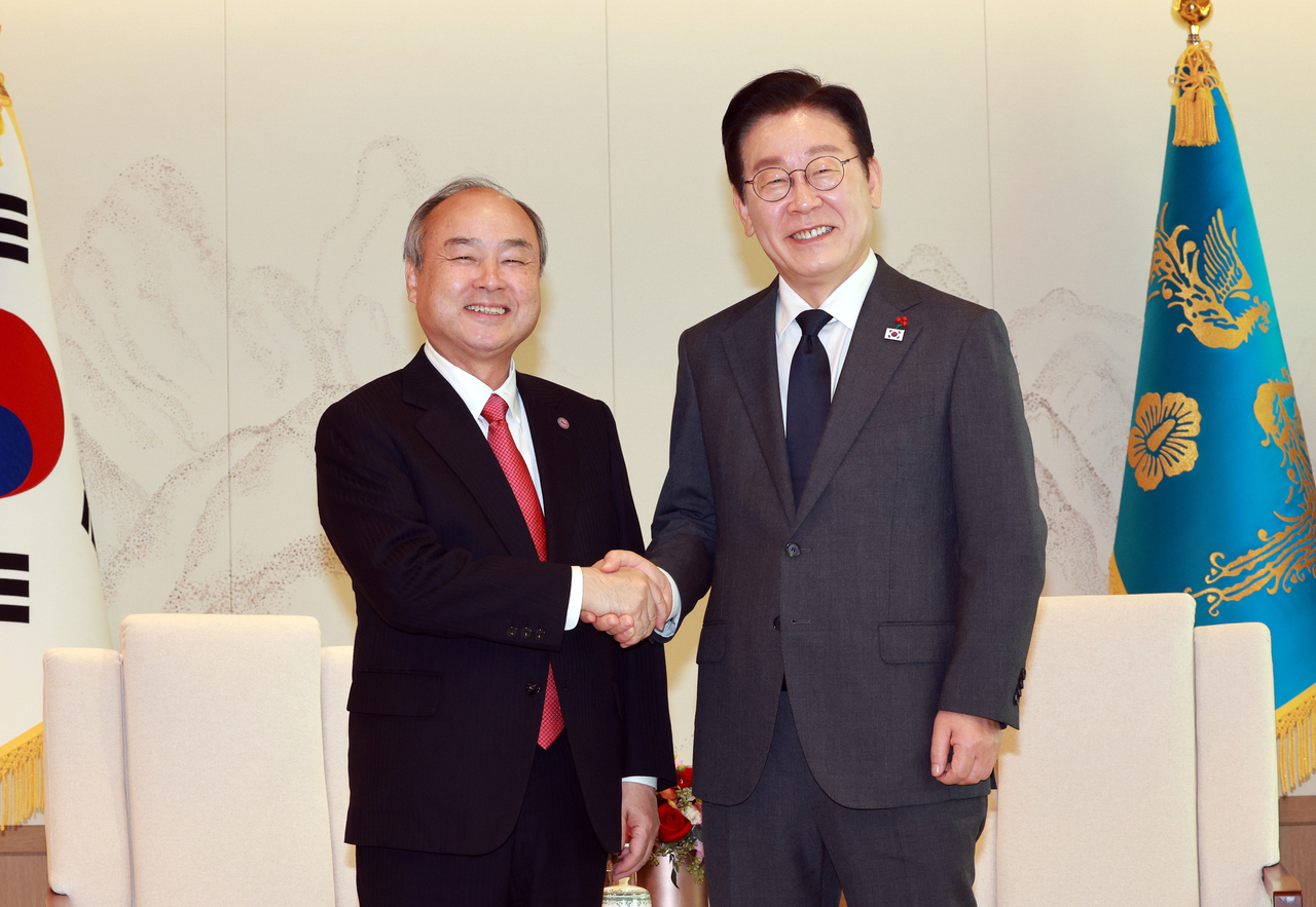 President Lee Jae Myung (right) shakes hands with Masayoshi Son, founder and CEO of SoftBank Group, at the presidential office in Yongsan-gu, central Seoul, Friday. (Joint Press Corps via Yonhap)