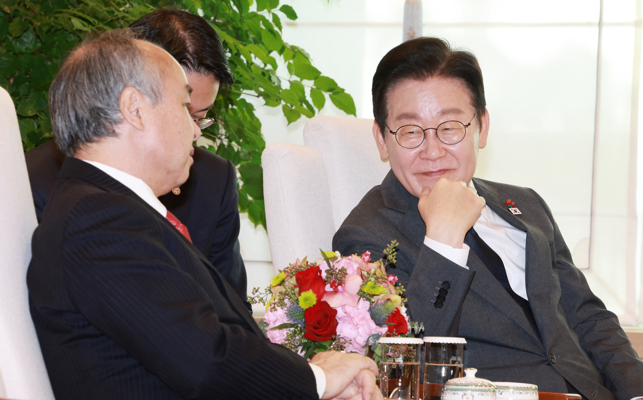 Masayoshi Son (left), founder and CEO of SoftBank Group, speaks with President Lee Jae Myung at the presidential office in Yongsan-gu, central Seoul, Friday. (Joint Press Corps via Yonhap)