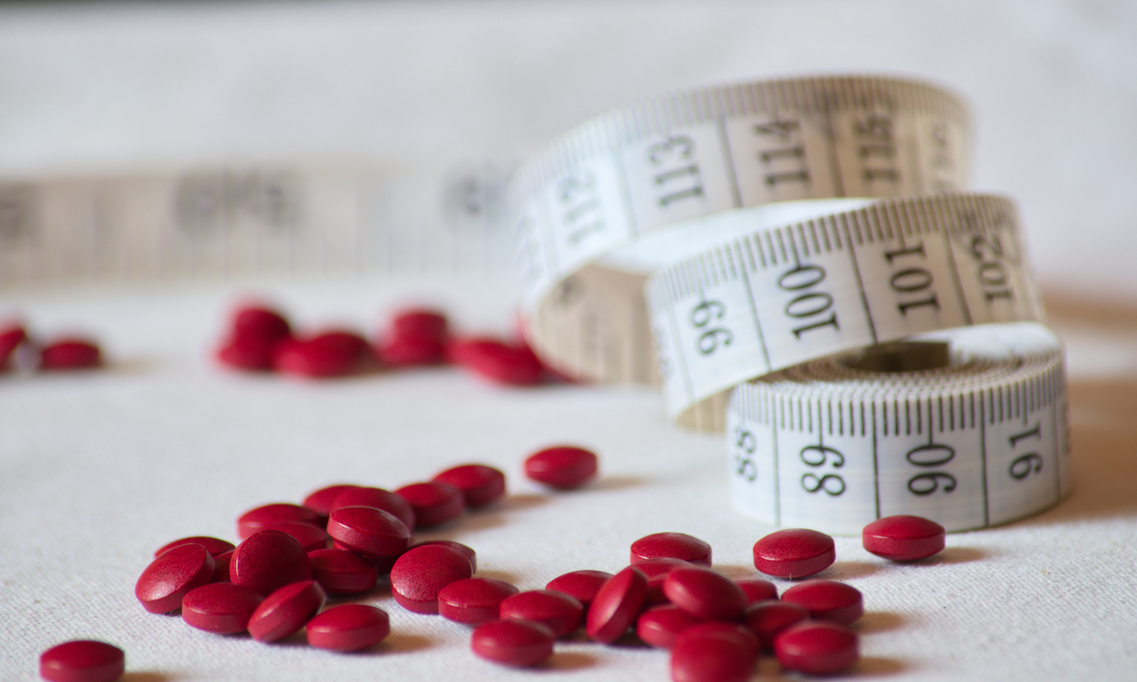 A pile of pills and a measuring tape illustrate rising demand for weight-loss medications amid increasing reports of misuse among non-obese users. (123rf)