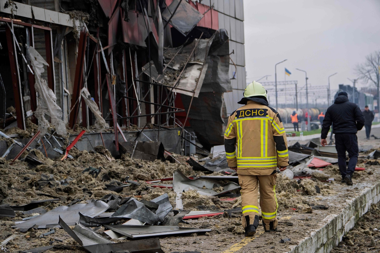 Ukrainian rescuers walk past a heavily damaged train station in Kyiv, Ukraine, Saturday. (AFP-Yonhap)