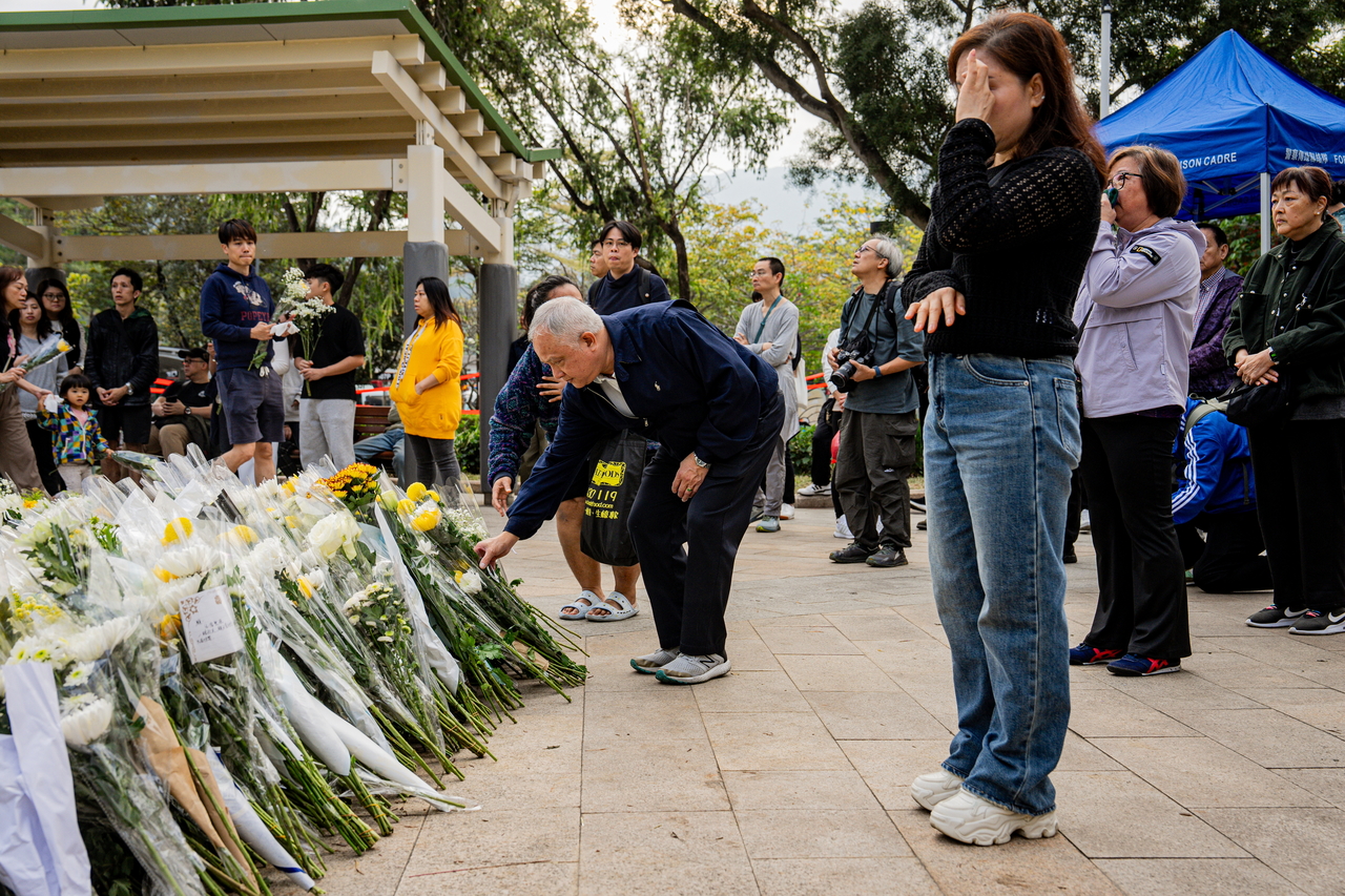 People leave flowers and pray near the site of a deadly fire at the Wang Fuk Court residential estate in Tai Po district, Hong Kong, Wednesday.  (Yonhap-EPA)