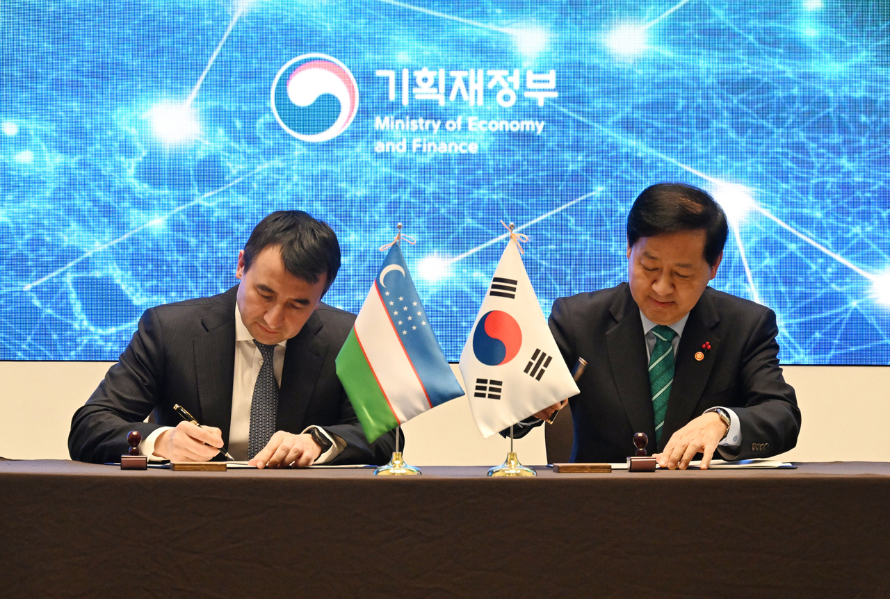 Deputy Prime Minister Koo Yun-cheol (right) and his Uzbek counterpart, Jamshid Khodjaev, sign a Memorandum of Understanding  at a meeting held in Seoul on Dec. 8, 2025, in this photo provided by the Ministry of Economy and Finance. (PHOTO NOT FOR SALE) (Yonhap)